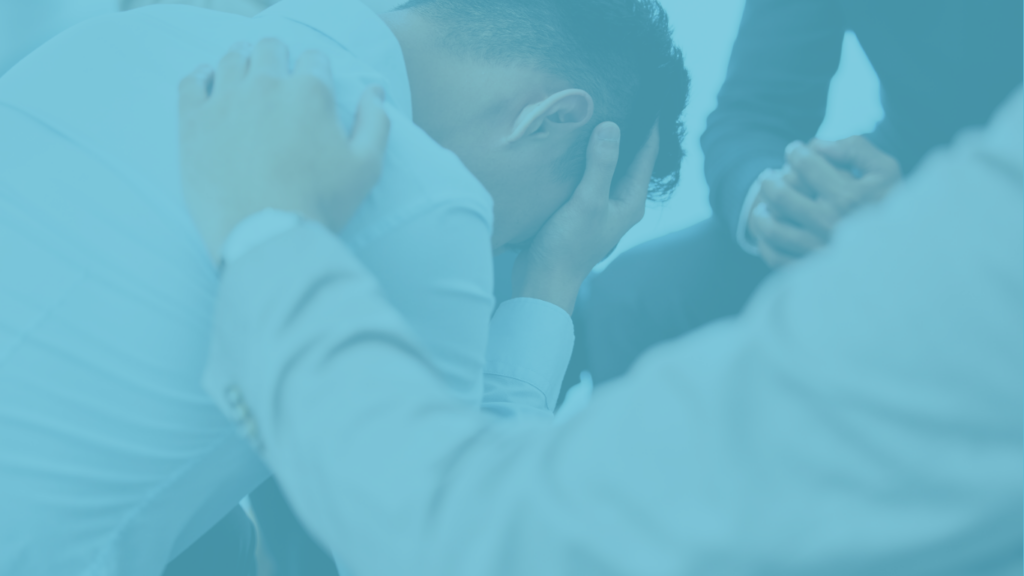 Man with head in his hands being comforted